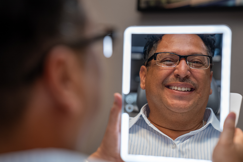 male patient smiling into a mirror