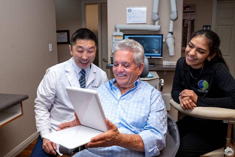 Hybrid Dental doctor, patient, and team member reviewing treatment together